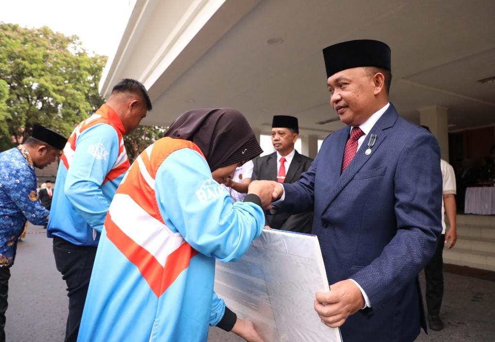 Bupati Bantaeng, Ilham Azikin secara simbolis menyerahkan bonus atlet peraih mendali di Pekan Olah Raga (Porprov) XVII 2022 tingkat Sulawesi Selatan pada momentum Hari Peringatan Nasional (Harkitnas) di Halaman Kantor Bupati Bantaeng, Kecamatan Uluere, Senin (22/5/2023).